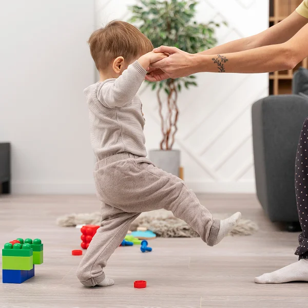 A woman and a child joyfully building structures with colorful Lego blocks on a table.
