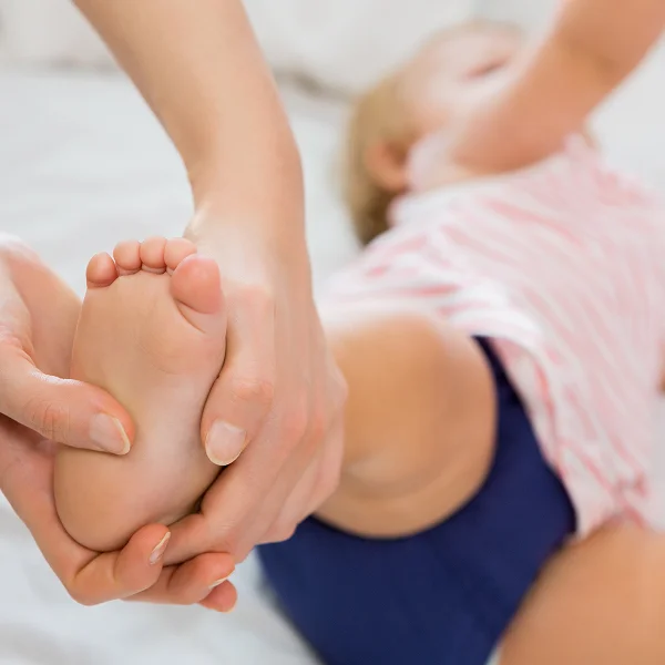 A person gently holds a baby's foot, showcasing a tender moment of connection and care.