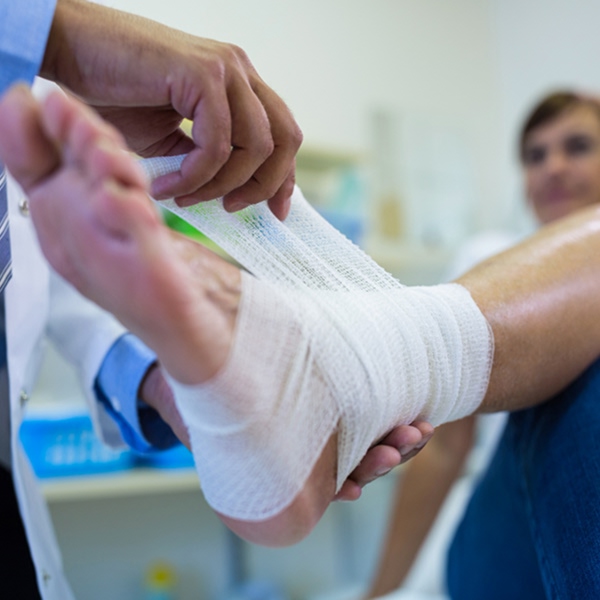 Doctor applying medical bandage to foot affected by osteoarthritis complications
